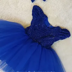 The royal blue party frock with its matching hair bow. Every detail is designed to make your little one feel like a princess.