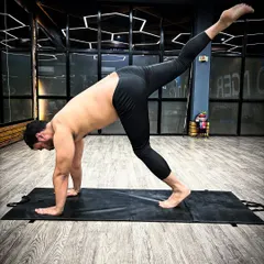 Practicing a variation of the Three-Legged Downward-Facing Dog pose. This asana is great for stretching the hamstrings and strengthening the upper body.