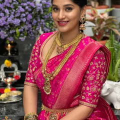 This bride is a vision in a vibrant pink Kanchivaram saree. Her blouse features matching pink fabric with intricate floral embroidery in gold thread, a classic choice for South Indian weddings.