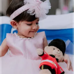 A heartwarming moment between the birthday girl and her teddy bear. This candid shot captures the innocence and sweetness of childhood during a first birthday party photoshoot.