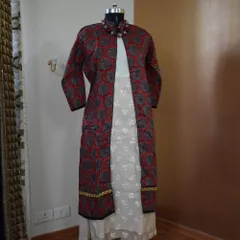 A full-length view of the poly-silk jacket set, showing how it creates a long, lean silhouette over the inner white kurta. The beaded necklace adds a perfect finishing touch.