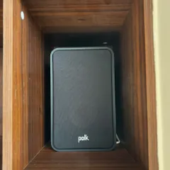 Here's the Polk Audio ES15 bookshelf speaker neatly placed within a custom wooden shelf. Its compact size allows for versatile placement without compromising on sound quality.