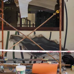 A candid shot from the work site. Creating large scale art involves scaffolding, patience, and a bit of organized chaos. This image shows the early stages of another mural, where the foundational shapes are just beginning to emerge.
