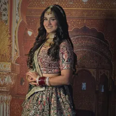 A beautiful bride in a deep green and maroon lehenga with heavy Marwari handwork. The traditional design is perfect for a classic wedding theme.