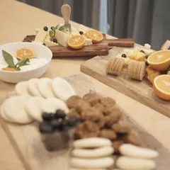A modern and minimalist presentation of several cheese boards. The arrangement includes a variety of cheeses, crackers, and dips, showcasing a clean and sophisticated approach to gourmet platters.