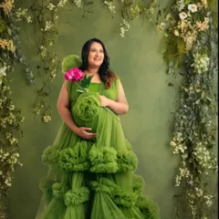 Surrounded by lush greenery, this mom-to-be looks like a woodland goddess. The vibrant green of the gown complements the natural backdrop perfectly.