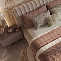 An overhead view shows the rich layering of textures in this girl's bedroom. The plush, channel-tufted headboard is complemented by a mix of quilted and patterned pillows in blush and grey tones, set against the delicate lines of the lotus mural.