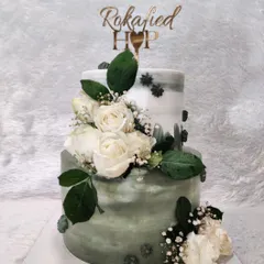 A beautiful two-tiered cake to celebrate a 'Rokafied' engagement. The sage green watercolor effect and fresh white roses create a sophisticated and modern look for this special pre-wedding ceremony.