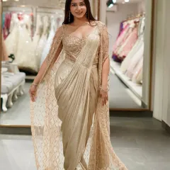 Get all the glamour of a saree without the fuss. This golden pre-draped saree comes with a stunning sequined bustier and a matching embellished cape, giving you a showstopper look in minutes.