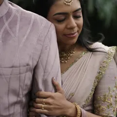 A close-up, intimate shot showing the delicate embroidery on the sleeve of Dr. Tushara's blouse.
