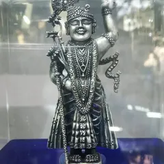 An exclusive handcrafted idol of Shreenath ji, made with 92.5 silver. The piece is shown in its display case, highlighting the antique finish and the detailed ornamentation that brings the deity to life.