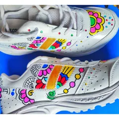 A side profile of the hand-painted sneakers, detailing the intricate line work and vibrant color blocking that flows across the shoe's panels.