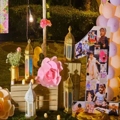 We love adding personal touches to your celebrations. For this first birthday, we created a large number '1' photo collage showcasing the baby's first year, surrounded by rustic wooden crates, lanterns, and paper flowers.