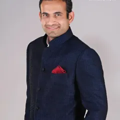 A portrait of cricketing icon Irfan Pathan in a navy textured Bandhgala. The ensemble is a study in balance and confidence, proving that a classic piece paired with a simple, bold accessory can stand apart.