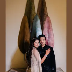 A stylish, full-length portrait of Richa and Chandresh. I help pose couples in a way that feels natural and elegant, complementing the beautiful backdrop and their outfits.