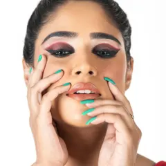 This shot highlights the symmetry and precision of the double-winged graphic liner. The combination of deep red and black eyeshadow adds depth and intensity to the model's gaze.