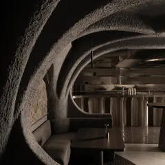 The interplay of light and shadow across the contoured concrete ceiling. This view showcases the architectural ribs that define the space, creating a sense of being inside a vast, organic structure.