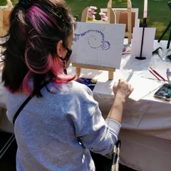 A participant at an outdoor painting event, recreating Van Gogh's "Starry Night." We provide all the materials, including easels, so you can just show up and paint.