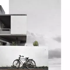 A stylized, artistic photograph of the Aayi House, emphasizing its strong geometric forms and minimalist aesthetic. The image captures the quiet poetry of the architecture.