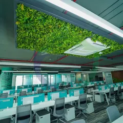 In this large open-plan office, we installed a green ceiling panel above the workstations. This not only adds a splash of nature but also helps with acoustics, absorbing sound in a busy environment.