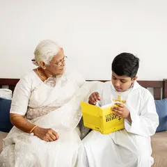 A grandmother shares a special moment with her grandson as he reads from the Bible during his Holy Communion. Capturing intergenerational connections during family events is so important.