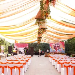An expansive view of the 'Art of Orange' Haldi setup, with vibrant orange drapes creating a warm and festive canopy for the celebration.