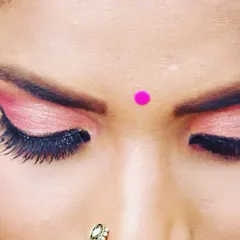 A close up on a soft glam eye makeup look. This features a blend of pink and shimmer eyeshadows with a clean winged liner, perfect for a festive or party occasion.