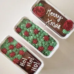 A closer look at the different designs for my Christmas rum cake loaves. One says "Ho! Ho! Ho!" and the other has a simple "Merry Xmas" message with piped red roses.