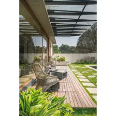 A wooden deck extends the living space outdoors, creating a perfect transition zone for relaxation that is sheltered by a glass pergola.