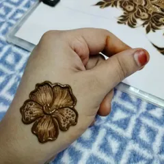 A single, perfectly executed hibiscus flower on the back of the hand. Practicing individual motifs like this is a great way to perfect your technique.