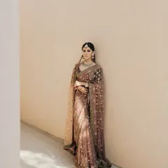 A minimalist and elegant portrait of Mouli in her beautiful Sabyasachi saree. The simple background allows the intricate details of her outfit to shine.