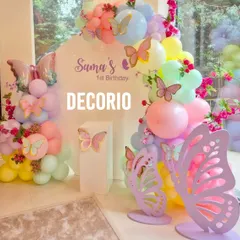 A whimsical butterfly-themed first birthday party, perfect for a magical celebration. The decor features a pastel rainbow balloon arch over a personalized backdrop, accented with delicate butterfly cutouts and fresh flowers.