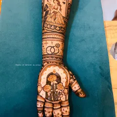 A full arm bridal design telling a complete story. The forearm features a framed portrait of the couple with their wedding date, while the palm has a beautiful design of roses under an arch.