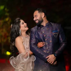 A candid moment of laughter and joy from a reception party, with the couple looking radiant in their evening wear.