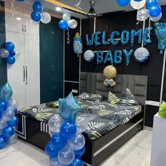 A full room decoration to welcome a baby boy. I used blue and white balloons to fill the space, with foil balloons spelling 'WELCOME BABY' over the bed and columns of balloons framing the room.