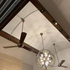 The ceiling design in this renovated Delhi home features exposed wooden beams and arched vaults, punctuated by a modern spherical chandelier. This combination of rustic structure and contemporary lighting is central to our adaptive reuse philosophy.