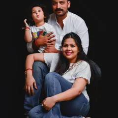 A striking family portrait using a bold, solid black background. This classic setup makes the family the complete focus, highlighting their connection and individual personalities.