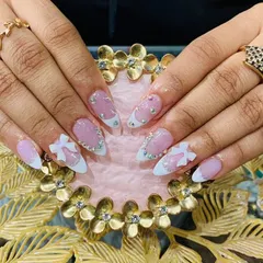 A cute and playful design with white French tips on a shimmery pink base, accented with 3D white bows and scattered rhinestones.
