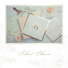 Gilded charm. This invitation suite is all about minimal elegance, with a stunning gold-foiled initial monogram taking center stage. The soft pastel colors and clean design create a sophisticated and timeless look.