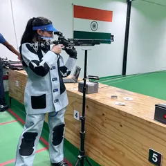 A female shooter in full gear during a 10-meter air rifle practice session, showcasing the discipline required for competitive shooting.