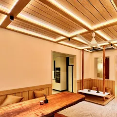 I designed this Zen-inspired dining area to be a space for connection and tranquility. The centerpiece is a live-edge wooden table, preserving the natural form of the tree. To create a unique, intimate setting, I designed a suspended bench that feels like a modern swing, encouraging a playful yet peaceful dining experience. The slatted wood ceiling with integrated lighting adds warmth and architectural rhythm.