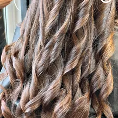 A close-up of a stunning hair transformation. The curls are defined, the color is rich, and the hair looks incredibly healthy.