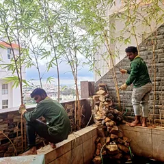Here our team is maintaining a beautiful balcony garden in Arekere. We're carefully tending to the bamboo plants near the custom rock waterfall, making sure this urban oasis stays serene and healthy.
