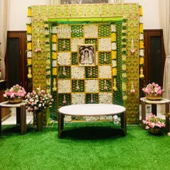 A full view of our elegant green and white floral backdrop. The artificial grass flooring and side floral arrangements complete the look, creating a perfect photo opportunity for your special day.