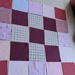 The initial layout of fabric squares for a patchwork quilt, showing the design process in its early stages.