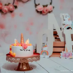 A close-up of the adorable unicorn cake before the smashing begins. The details, from the golden horn to the sleepy eyes, are just too cute.