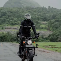 Me riding my motorcycle on a wet road with lush green hills in the background. This photo embodies the classic monsoon road trip experience in the Western Ghats.