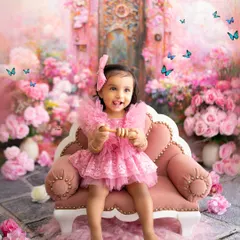 A princess in her pink palace garden. This stunning backdrop, filled with pink blossoms and magical butterflies, creates a true fairytale setting for a first birthday.