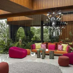 This vibrant living area is designed to feel like a part of the garden. The large, openable glass walls and retractable roof allow sunlight and fresh air to flood the space, creating a perfect setting for lively conversations and relaxation.