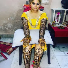 A full bridal look, with intricate mehndi covering the hands, arms, and legs up to the knees. This is the ultimate in bridal henna adornment.